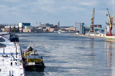Ventspils, Letonya, 6 Şubat 2021: Liman kanalında iki römorkör, endüstriyel arka plan