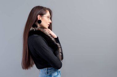 Gri arka planda uzun saçlı şehvetli bir kadının portresi.