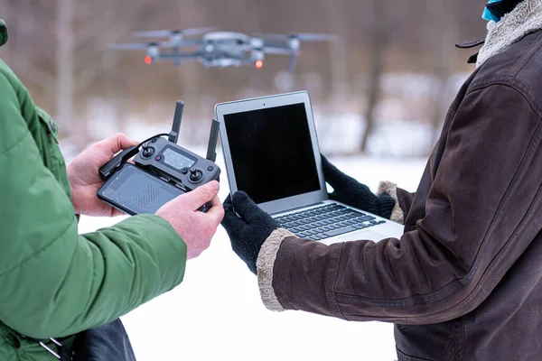 area planners survey the surroundings with a drone, close-up of a hand with a drone remote controller and a laptop, area planning and monitoring concept