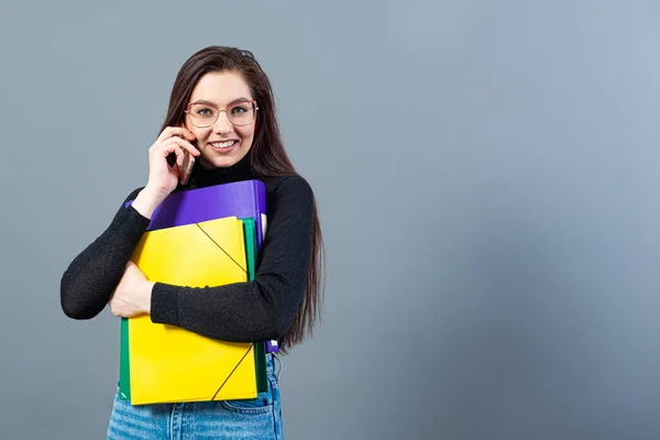 Mulher Com Smartphone Segurando Uma Pastas Coloridas Com Documentos Isolado — Fotografia de Stock