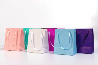Beyaz arkaplanda izole edilmiş renkli kağıt alışveriş torbaları, tasarım için model