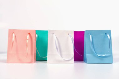 Beyaz arkaplanda izole edilmiş renkli kağıt alışveriş torbaları, tasarım için model