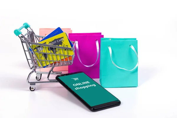 智能手机 带有信用卡和彩色纸袋的迷你购物车 在白色的电子商务中被隔离 — 图库照片