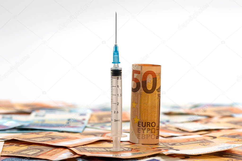 Close-up syringe and euros banknotes bills. Cost of health, medicine, drug concept