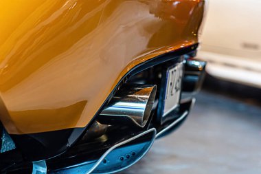 Modern lüks araba, çift egzoz boruları, havayı kirleten araç dumanı.