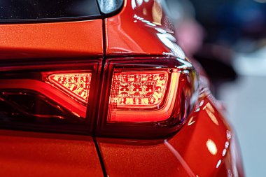 Modern bir arabanın kırmızı arka lambasına yakın çekim, bir arabanın arka lambasındaki detay...