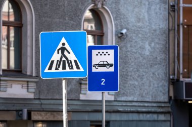 Binanın arka planında yaya geçidi ve taksi parkı tabelası, yakın plan.