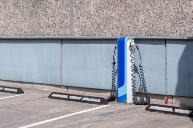 Elektrik kablosu olan elektrikli araba için açık hava otoparkında şarj istasyonu terminali.