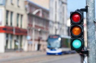 Şehir trafiğinin arka planına yeşil ışık yakılmış küçük bir trafik semaforu.