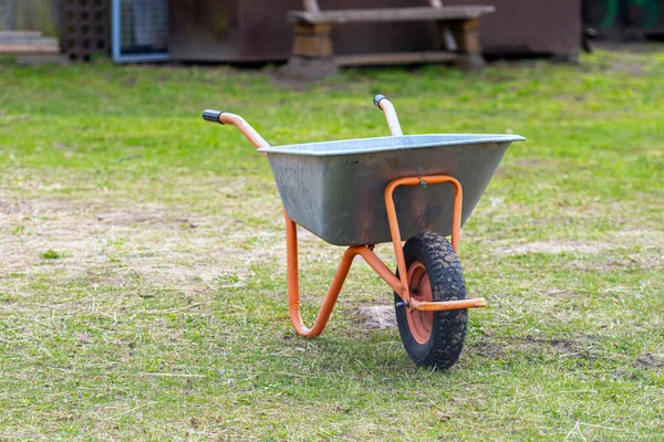 wheelbarrow closeup on a lawn in garden, work in garden, garden maintenance