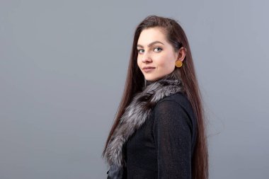 Uzun saçlı, gri arkaplan ve fotokopi alanı olan genç, şehvetli bir kadının portresi.