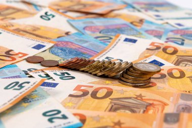 Avro banknotlarının arka planında madeni paralar, ekonomik ve ticari sistemin bir parçası olarak Avro faturası, yakın plan