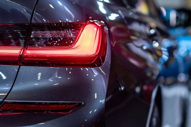 Modern bir arabanın kırmızı lambasına yakın çekim, arabanın arka lambasındaki detay...