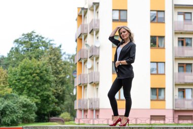 Bulanık şehir arka planına karşı genç, pozitif, zarif bir iş kadınının portresi.