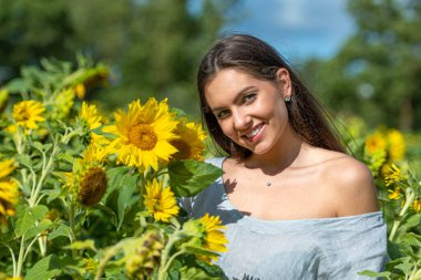 Ayçiçeği tarlasında oldukça şehvetli genç bir esmer, genç bir kadın portresi