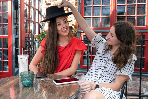 2人の陽気な若い女性がコーヒーを飲み屋外カフェで話し笑い — ストック写真