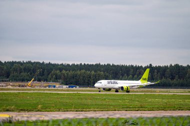 Riga, Letonya - 31 Ağustos 2021: AirBaltic Airbus A220-300 YL-AAS İniş / Geliş Riga / RIX / EVRA Havalimanı Bulutlu Sonbahar Günü