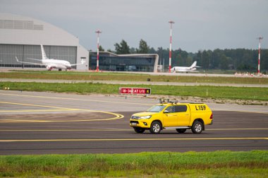 Riga, Letonya - 31 Ağustos 2021: Riga Uluslararası Havaalanı 'nda sarı havacılık kuş kontrol aracı (RIX)