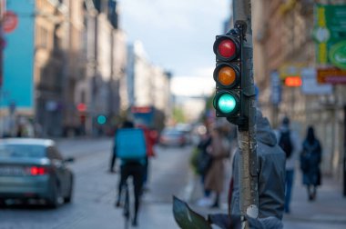 Trafik ışıklarıyla şehir trafiğini bulanık görmek, ön planda yeşil ışığı olan bir semafor.