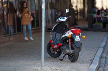 Riga, Letonya - 3 Eylül 2021: Kiralık scooter 'ın park ettiği kaldırımdaki eski kasabada