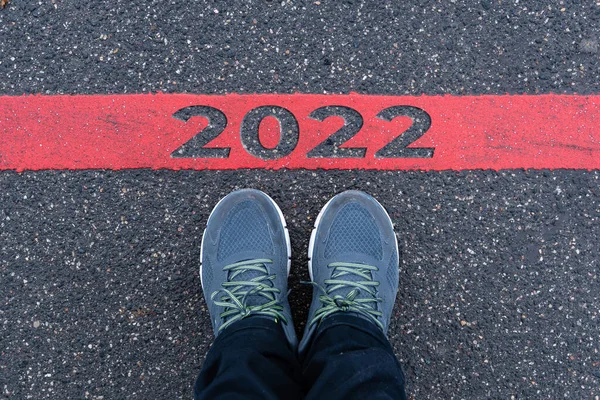 Bovenaanzicht Van Mannelijke Sneakers Asfaltweg Met Tekst 2022 Rode Lijn — Stockfoto