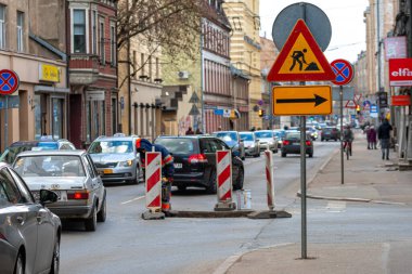 Riga, Letonya - 7 Nisan 2021 Tallinn ve Terbatas caddelerinin kesişiminde sokak tamiratı, sınırlı trafik ve uyarı levhaları