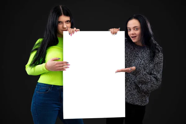 Δύο Ελκυστικές Αστείες Νεαρές Γυναίκες Λευκή Λευκή Αφίσα Απομονωμένες Σκούρο — Φωτογραφία Αρχείου