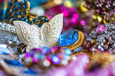 Çeşitli renkli parlak mücevherler ve kostüm mücevherlerinin soyut arkaplanı, yumuşak, seçici odaklanma