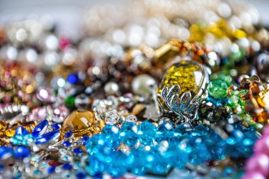 Çeşitli renkli parlak mücevherler ve kostüm mücevherlerinin soyut arkaplanı, yumuşak, seçici odaklanma