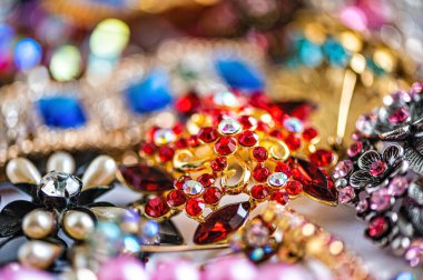 Çeşitli renkli parlak mücevherler ve kostüm mücevherlerinin soyut arkaplanı, yumuşak, seçici odaklanma