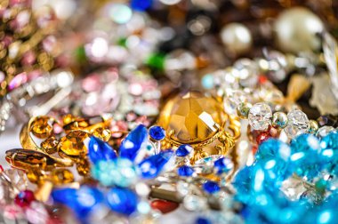 Çeşitli renkli parlak mücevherler ve kostüm mücevherlerinin soyut arkaplanı, yumuşak, seçici odaklanma