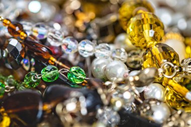 Çeşitli renkli parlak mücevherler ve kostüm mücevherlerinin soyut arkaplanı, yumuşak, seçici odaklanma