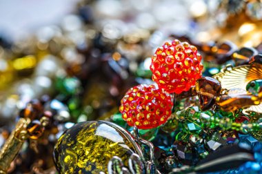 Çeşitli renkli parlak mücevherler ve kostüm mücevherlerinin soyut arkaplanı, yumuşak, seçici odaklanma