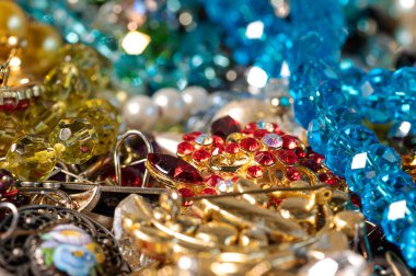 Çeşitli renkli parlak mücevherler ve kostüm mücevherlerinin soyut arkaplanı, yumuşak, seçici odaklanma