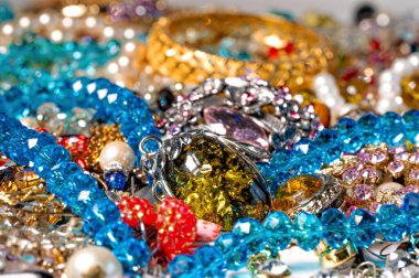 Çeşitli renkli parlak mücevherler ve kostüm mücevherlerinin soyut arkaplanı, yumuşak, seçici odaklanma