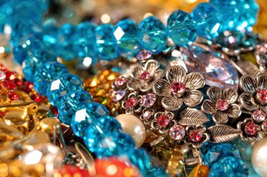 Çeşitli renkli parlak mücevherler ve kostüm mücevherlerinin soyut arkaplanı, yumuşak, seçici odaklanma