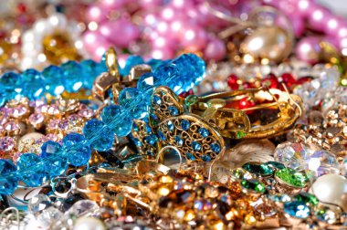 Çeşitli renkli parlak mücevherler ve kostüm mücevherlerinin soyut arkaplanı, yumuşak, seçici odaklanma