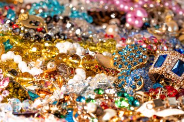 Çeşitli renkli parlak mücevherler ve kostüm mücevherlerinin soyut arkaplanı, yumuşak, seçici odaklanma