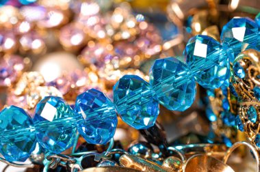 Çeşitli renkli parlak mücevherler ve kostüm mücevherlerinin soyut arkaplanı, yumuşak, seçici odaklanma