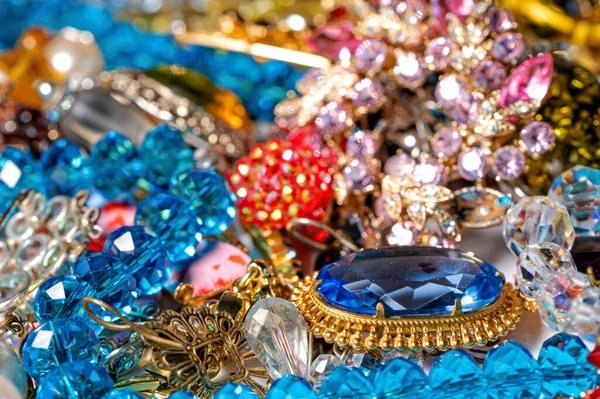 Çeşitli renkli parlak mücevherler ve kostüm mücevherlerinin soyut arkaplanı, yumuşak, seçici odaklanma