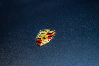 Riga, Letonya, 24 Eylül 2021: Mavi arabanın kaputunda Porsche şirketinin logosu görülüyor.