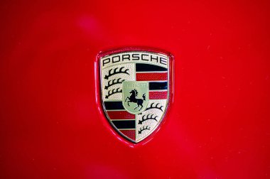 Riga, Letonya, 24 Eylül 2021: Porsche şirketinin logosu kırmızı arabanın kaputunda, yakın plan