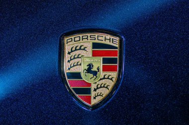 Riga, Letonya, 24 Eylül 2021: Mavi arabanın kaputunda Porsche şirketinin logosu görülüyor.
