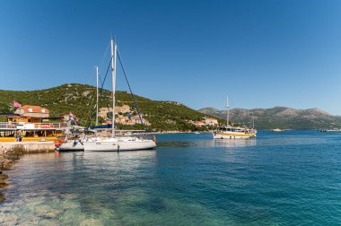 Kolocep Adası, Dubrovnik, Hırvatistan - 19 Eylül 2025: Yelkenliler Kolops adasında huzur içinde yüzerek açık mavi suların ve güneşli havanın tadını çıkarıyorlar.