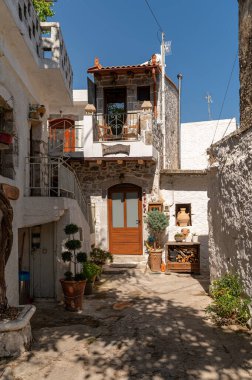 Girit 'in Krasi kentindeki antika avluda samimi taş binalar ve canlı saksı bitkileri bulunuyor..