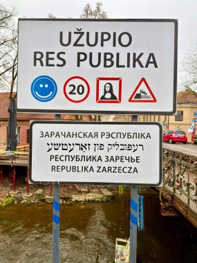 Vilnius, Litvanya, 20 Aralık 2025: Uzupios bölgesinde birden fazla dilde ve sembolde bilgi gösteren bir işaret.