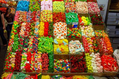 Barselona, İspanya - 28 Nisan 2009: İnsanlar Barcelona 'daki bir pazarda büyük bir renkli şeker ve şeker sergisinin önünden geçtiler.