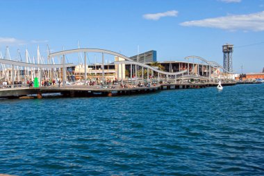 Barselona, İspanya - 28 Nisan 2009: İnsanlar güneşli bir günde Barcelona 'nın limanında eğimli bir yürüyüş yolu boyunca yürür.