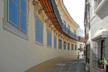 Barselona, İspanya - 29 Nisan 2009: Barcelona 'da eğri bir cadde açık gökyüzünün altında mavi pencereli beyaz binalar gösteriyor.