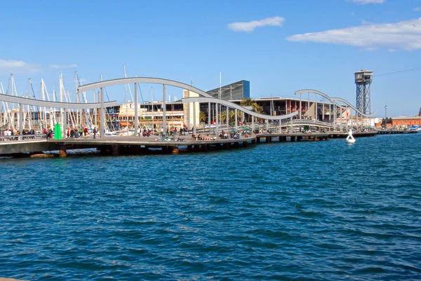 Barselona, İspanya - 28 Nisan 2009: İnsanlar güneşli bir günde Barcelona 'nın limanında eğimli bir yürüyüş yolu boyunca yürür.